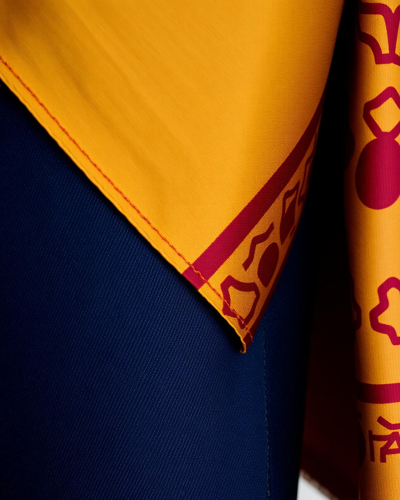 Hand-woven Cambodian pidan silk in gold and burgundy draped over dark indigo denim.